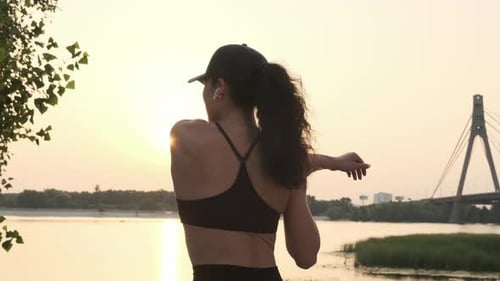 Back View of Young Slim Woman Doing Exercises Outdoors at the Sunset