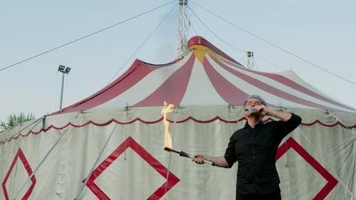 Adult Performing Fire Breathing Stunt Near Circus Tent