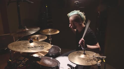 Drummer performing in a studio setting.