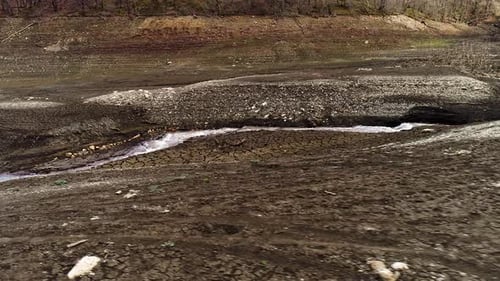 Narrow stream with strong current on dry land