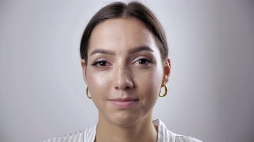 Attraktiv lächelnd selbstbewusst junge Frau hübsches Gesicht Blick in die Kamera posiert allein im Studio posiert