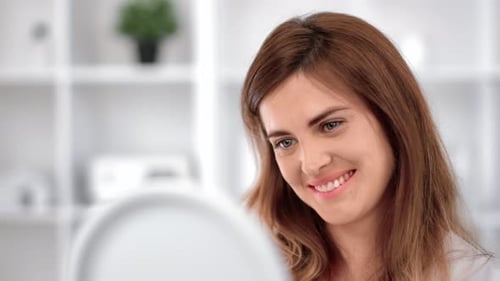 Attractive Woman Smiling Looking at Herself in Mirror