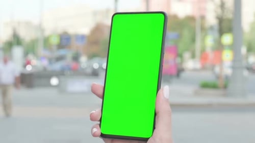 Close Up of Female Hand Using Smartphone with Green Screen Outdoor