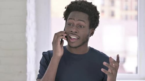 Man Using Smartphone and Talking Indoors