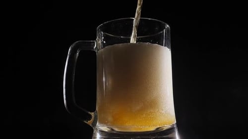 Close-up of Beer Poured Into a Beer Mug That Slowly Turns on a Black Background