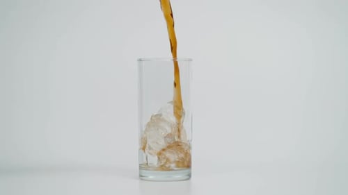 Soda Pouring into Glass of Ice
