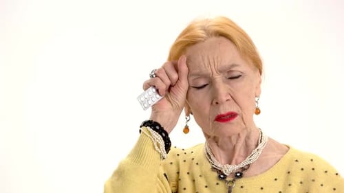 Senior Woman With Headache Holding Pills