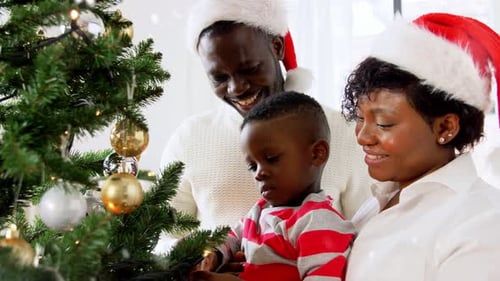Cheerful Family Decorating Christmas Tree at Home