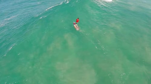 Aerial view of a man sup stand-up paddleboard surfing in Waimea, Hawaii
