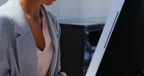 Side view of African American Businesswoman working on computer at desk in a modern office 4k