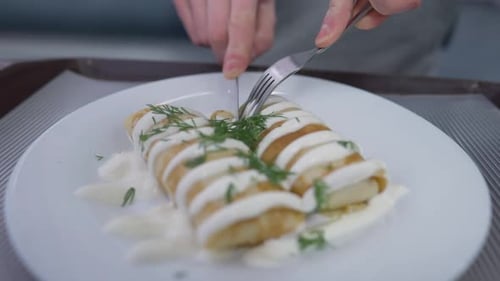 Crepes with White Sauce Being Cut