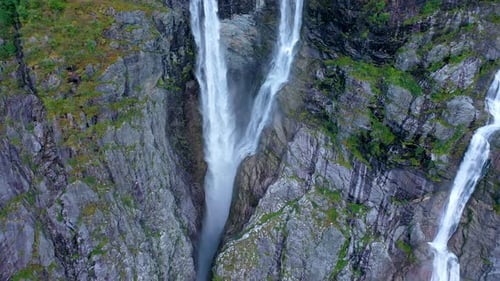 Stunning high twin waterfall flowing from a tall mountain - Pan view