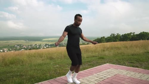Man Jumps Rope on a Grassy Field