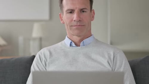 Man Using Laptop Computer in Home Office