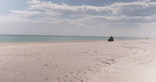 Couple ride on Quad bike near the Ocean. Adventures in the sand beach off-road on ATV