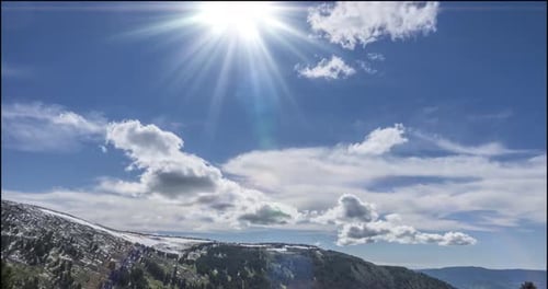 Zeitraffer der Wolkenlandschaft hinter dem Gipfel der Berge. Schnee, Felsen, Klippen und tiefblauer Himmel.
Hoch