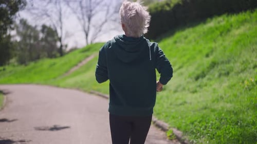 Active Senior Woman Running in Urban Park