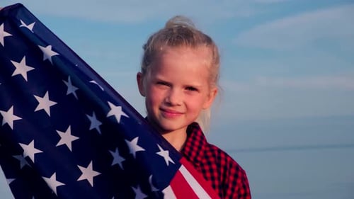 Girl Smiling and Holding an American Flag