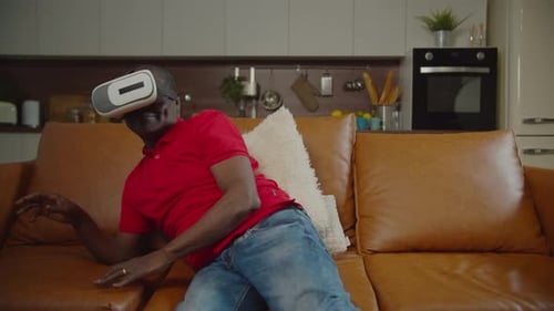 Man Using VR Headset on Couch in Living Room