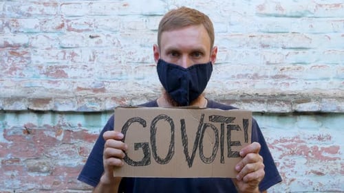 Young Adult Holding Go Vote Sign and Pointing