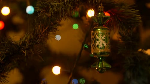 Christmas Tree with Lighting Garland and Decortive Toy on Branches Close Up