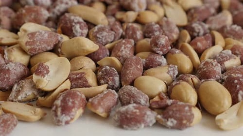 Lot of roasted peanuts on white background 4K 2160p 30fps UltraHD tilting footage - Tasty snack Arac