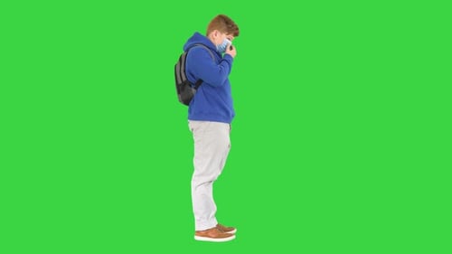 Teenager Boy Wearing Respiratory Protective Medical Mask on a Green Screen Chroma Key
