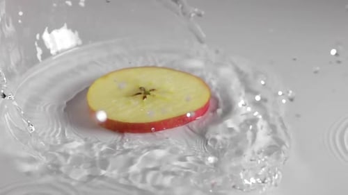 Apple Slice Splashing into Water, Refreshing Food Concept