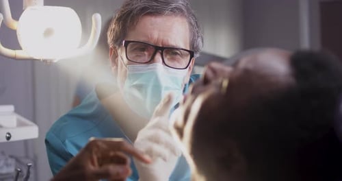 Dentist Examines Patient's Teeth in Clinic