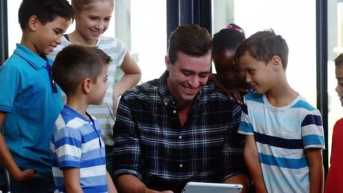 Children Gather Around Teacher with Tablet in Classroom