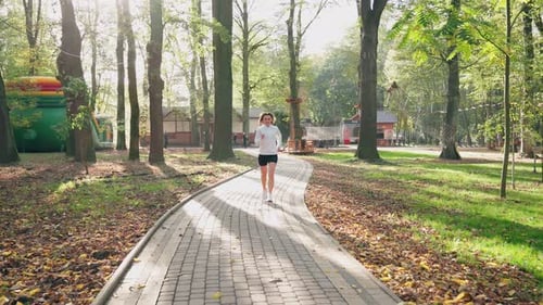 Woman in Activewear Running at Park