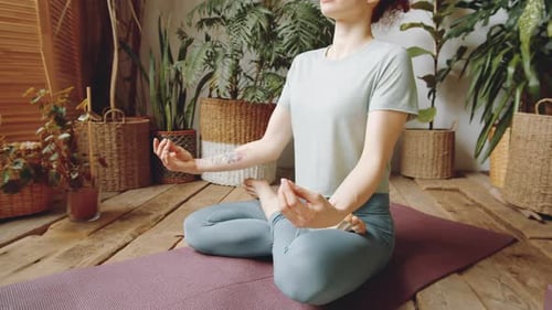 Woman Meditating in Lotus Position at Home