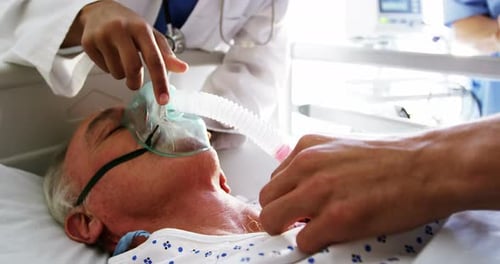 Senior Patient Receives Medical Attention in Hospital Bed