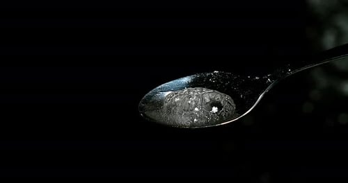 Drug, Cocaine in spoon against black background, Slow motion 4K