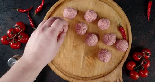 Meatballs Being Placed on a Wooden Platter