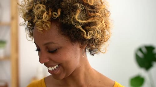 Smiling Young Woman with Curly Hair in Home