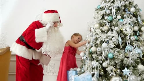 Girl Decorates Christmas Tree With Santa Claus