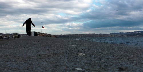 Figure Walking on Seawall Next to the Ocean