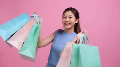 Happy Woman Holding Shopping Bags in Studio