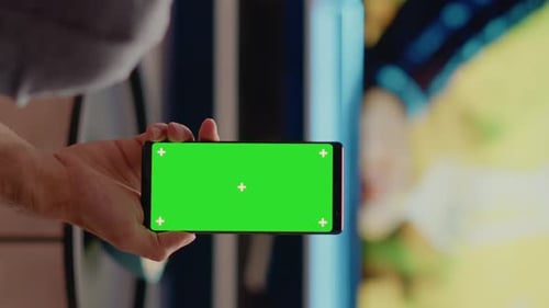 Vertical Video Person with Modern Smartphone Looking at Green Screen
