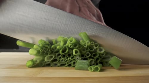 Green Onion are Cut with Knife in Kitchen