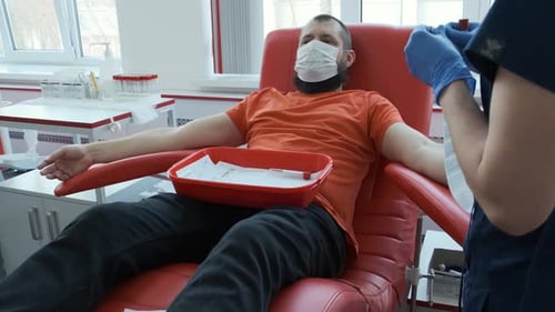 Man Sits in Medical Chair During Blood Donation