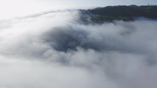 Aerial View of Clouds with Hilltops in Distance