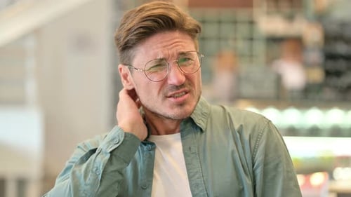 Man with Neck Pain Rubbing Neck in Discomfort