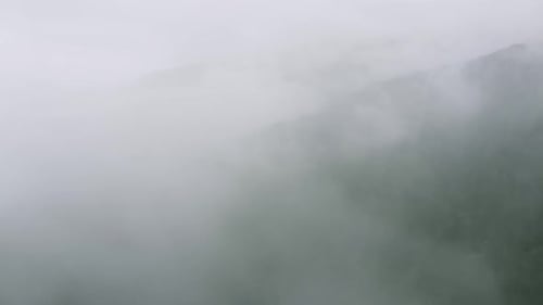 Aerial View of Mountain Forest in Thick Clouds