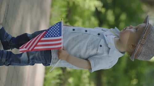 Child Holding American Flag in Park