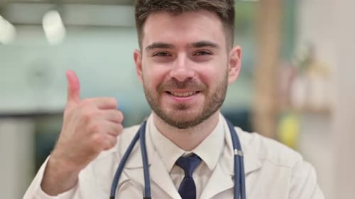 Positive Young Doctor Showing Thumbs Up Sign