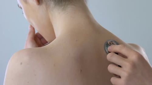 Medical Professional Listening to Patient's Back with Stethoscope
