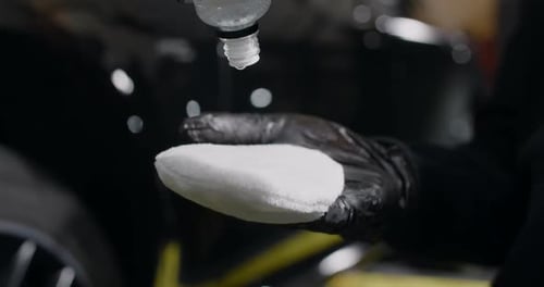 Detailer Applies Liquid to Microfiber Cleaning Pad