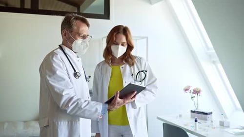 Doctors Reviewing Medical Data on Tablet in Clinic